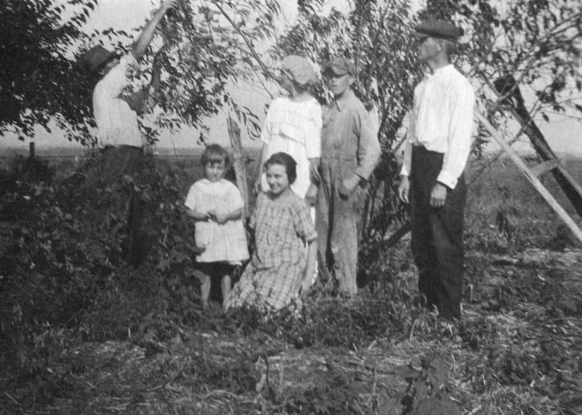 The family near trees on the farm.